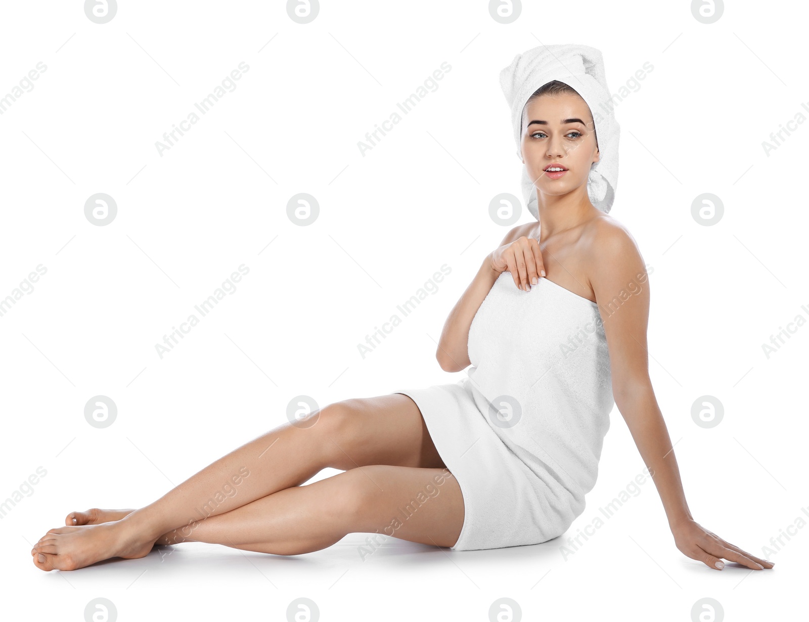 Photo of Portrait of young pretty woman with towels sitting on white background