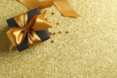 Photo of Beautifully wrapped gift box and decor on golden background, flat lay. Space for text