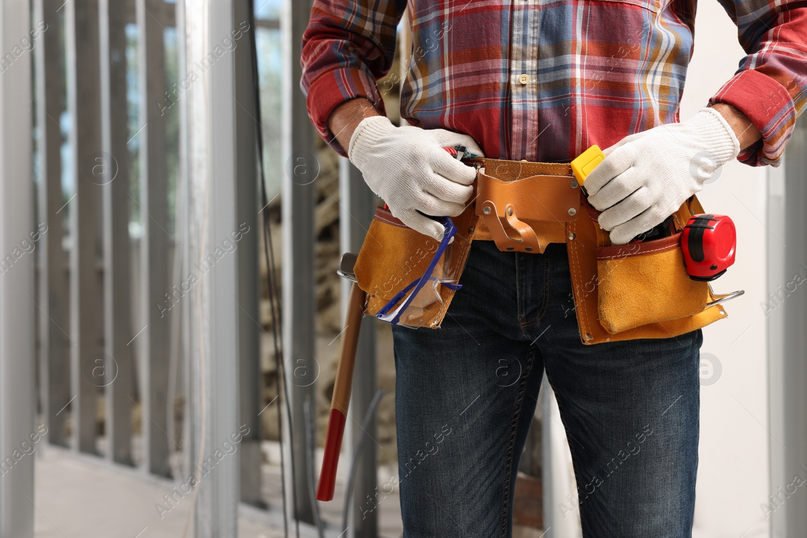 Photo of Professional builder with tool belt indoors, closeup