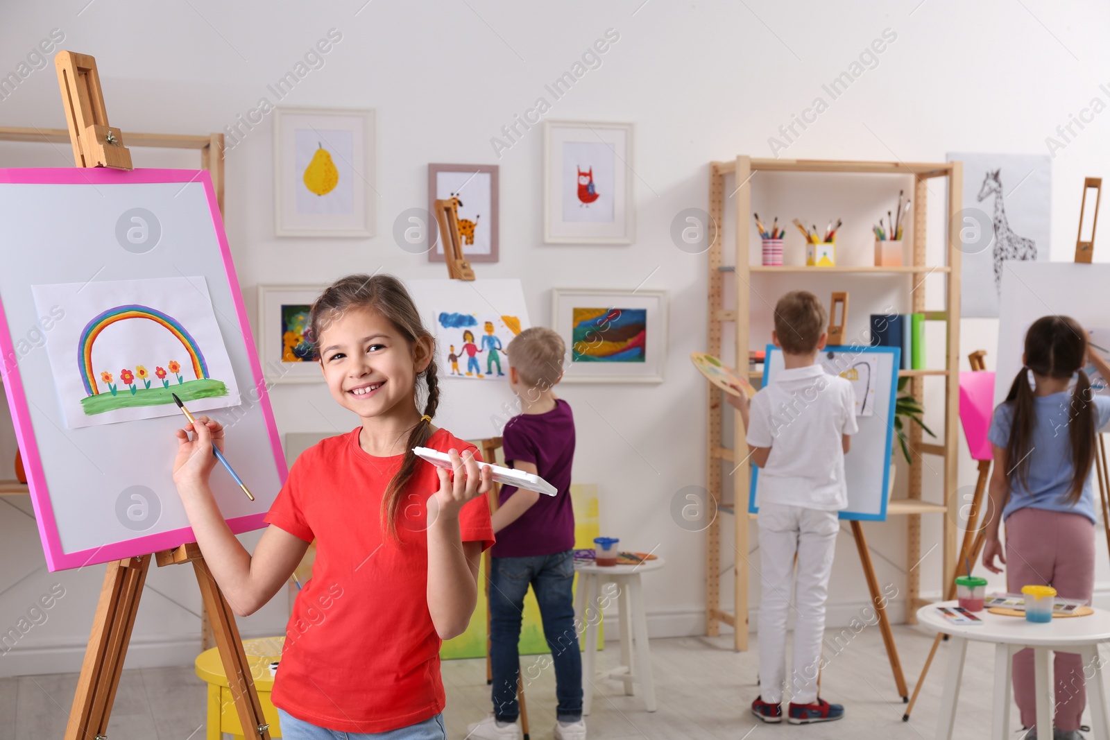 Photo of Cute little child painting during lesson in room