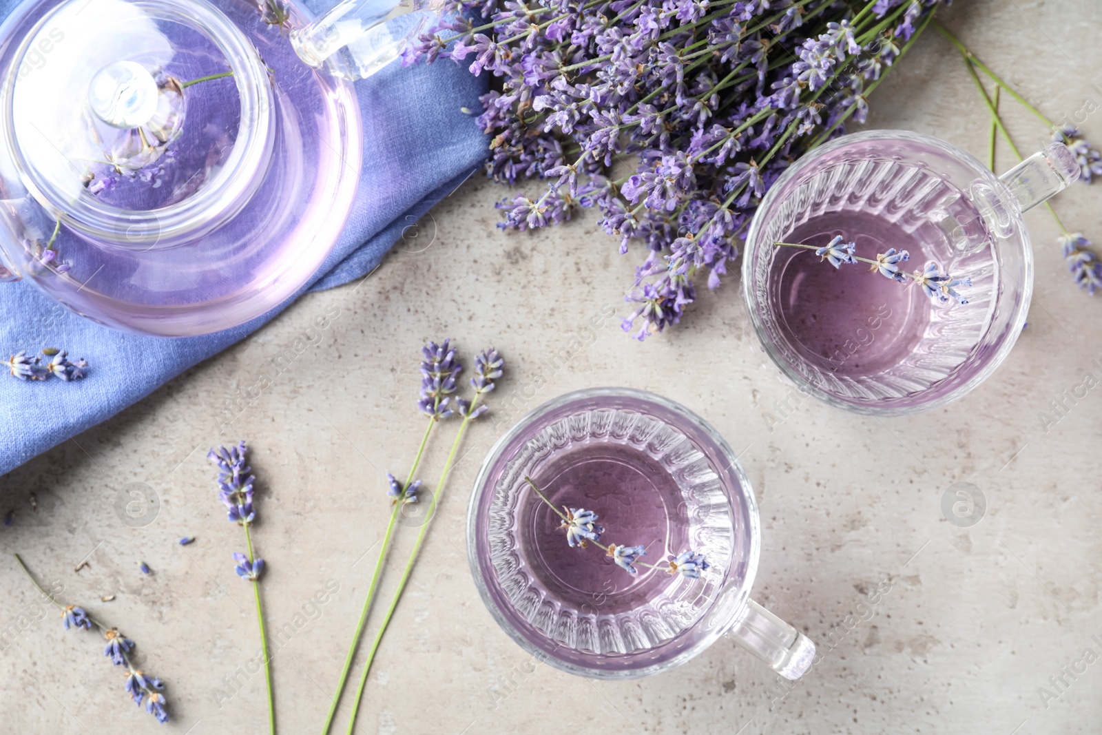 Photo of Fresh delicious drink with lavender in glass cups on grey table, flat lay