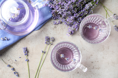 Fresh delicious drink with lavender in glass cups on grey table, flat lay