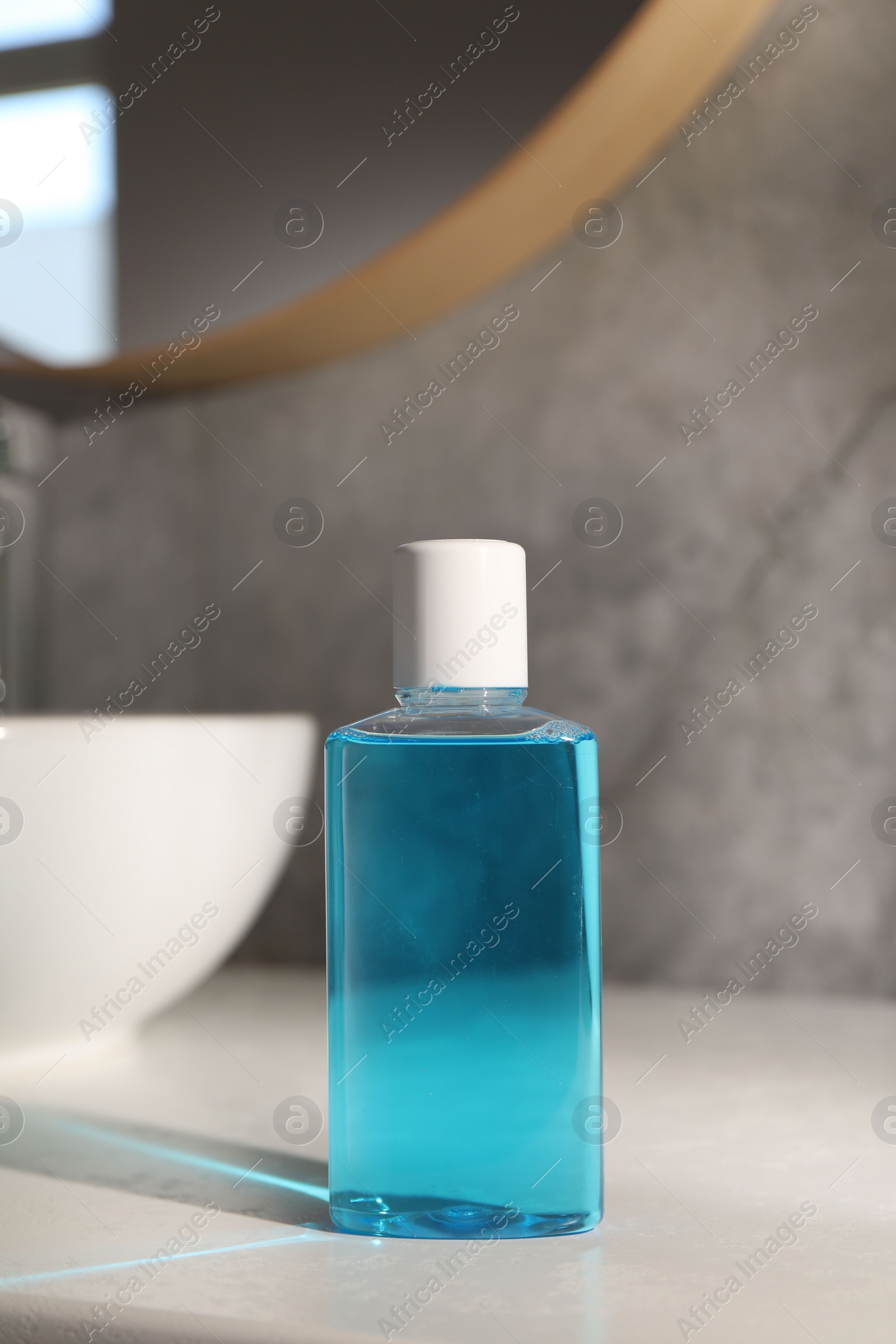 Photo of Bottle of mouthwash on light table in bathroom