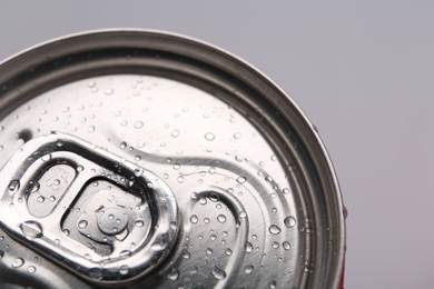 Energy drink in wet can on light grey background, closeup