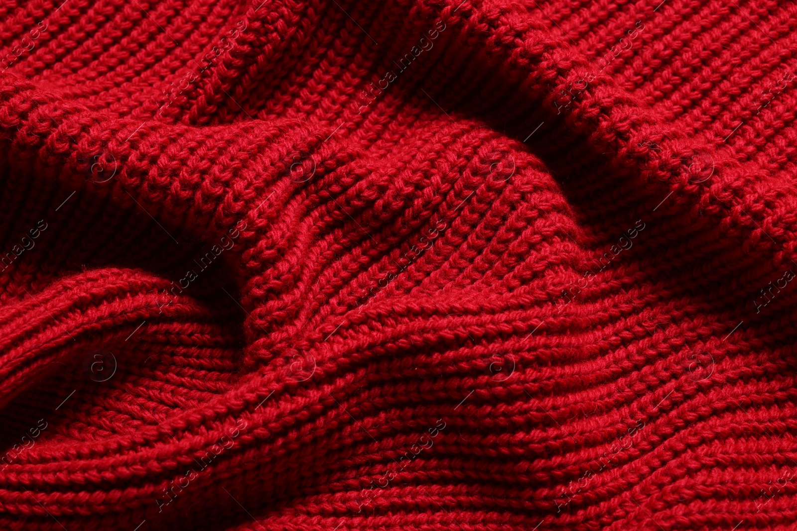 Photo of Texture of soft red knitted fabric as background, top view