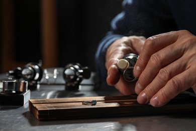 Photo of Professional jeweler working with ring at table, closeup