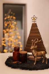 Composition with decorative Christmas tree and reindeer on light table, closeup