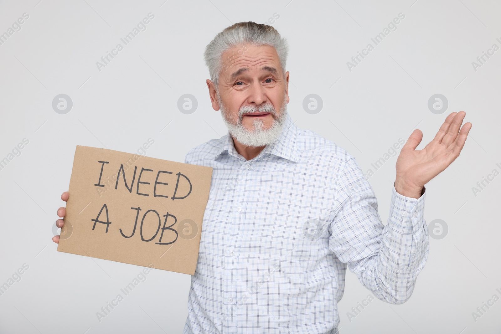 Photo of Unemployed senior man holding cardboard sign with phrase I Need A Job on white background