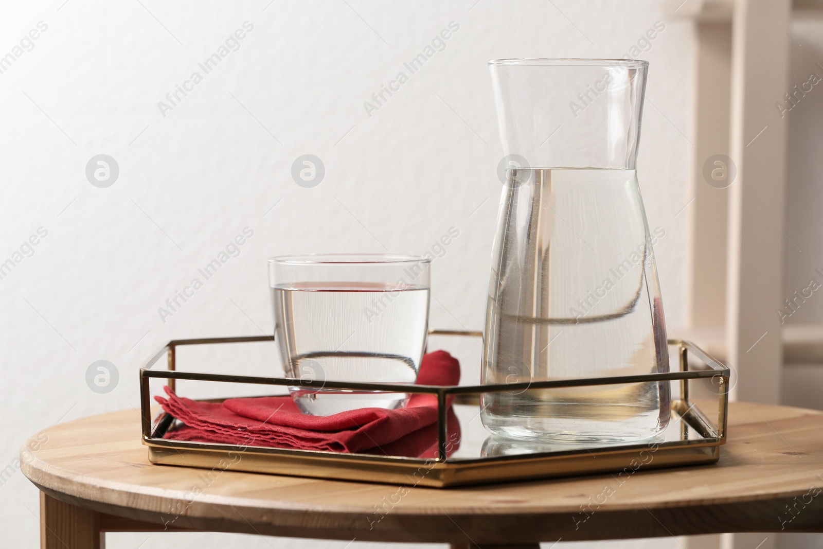 Photo of Carafe and glass with water on table indoors. Space for text