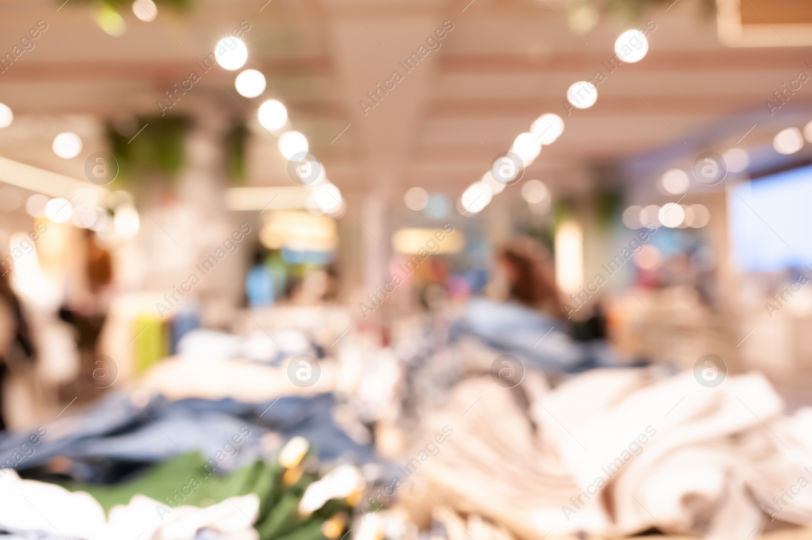 Photo of Blurred view of modern boutique interior with stylish clothes