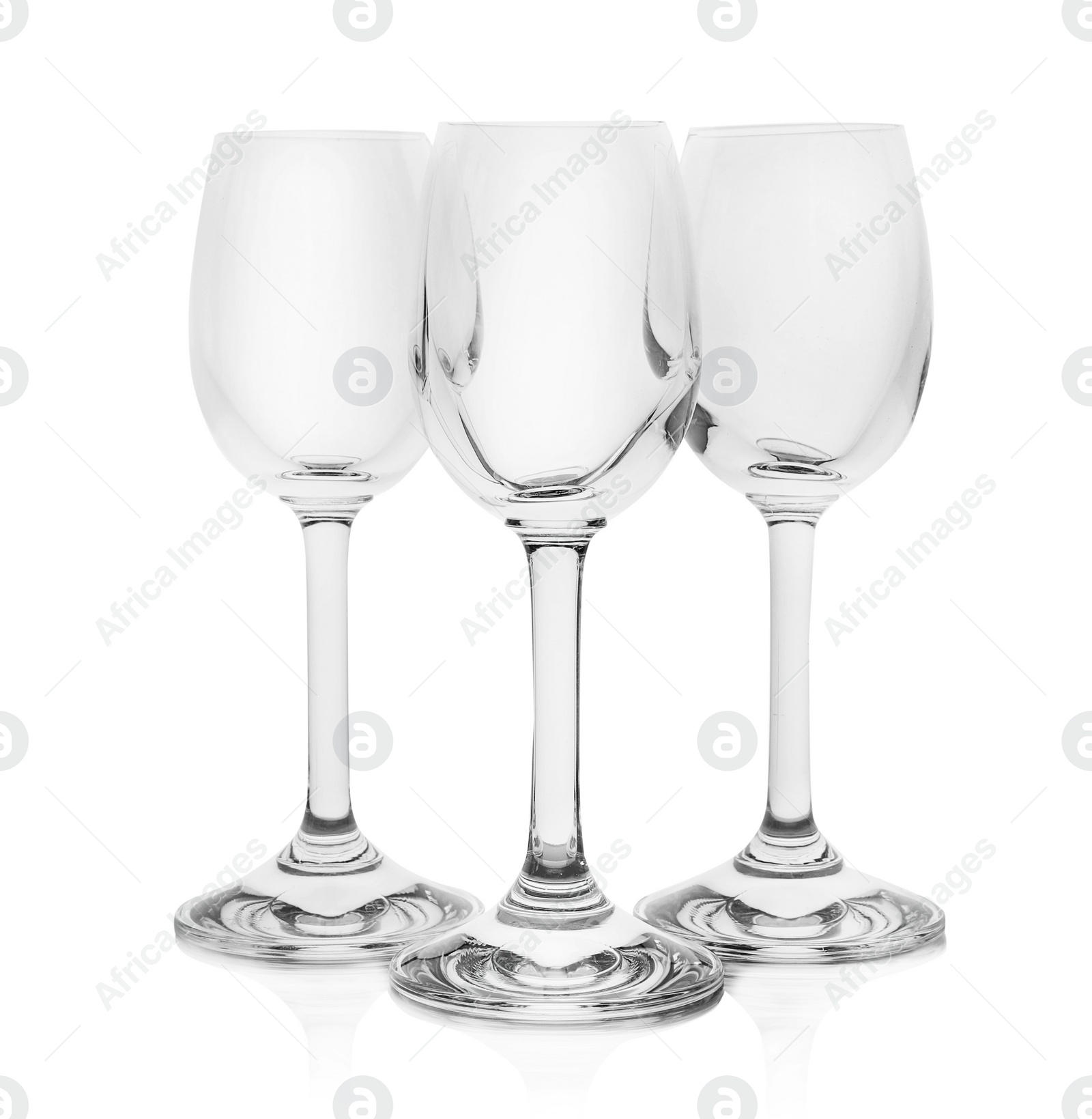 Photo of Empty clear glasses for liquor on white background