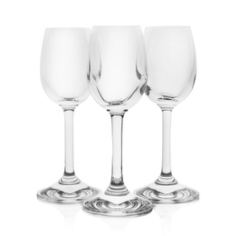 Photo of Empty clear glasses for liquor on white background