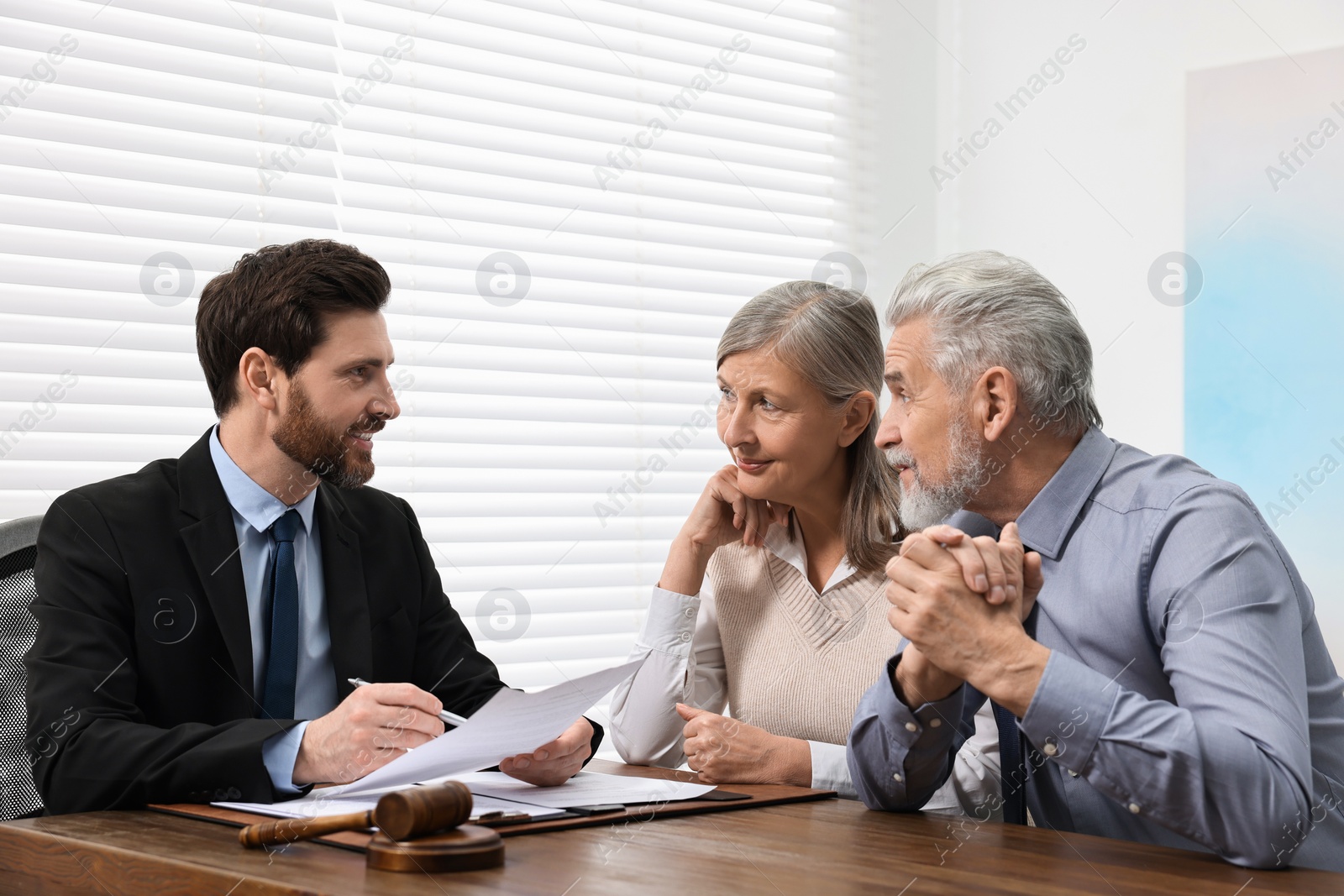 Photo of Senior couple having meeting with lawyer in office