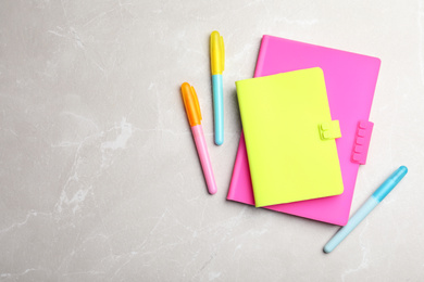 Photo of Stylish notebooks and pens on marble table, top view. Space for text