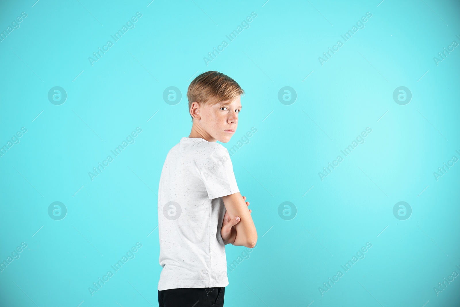 Photo of Portrait of young boy standing against color background