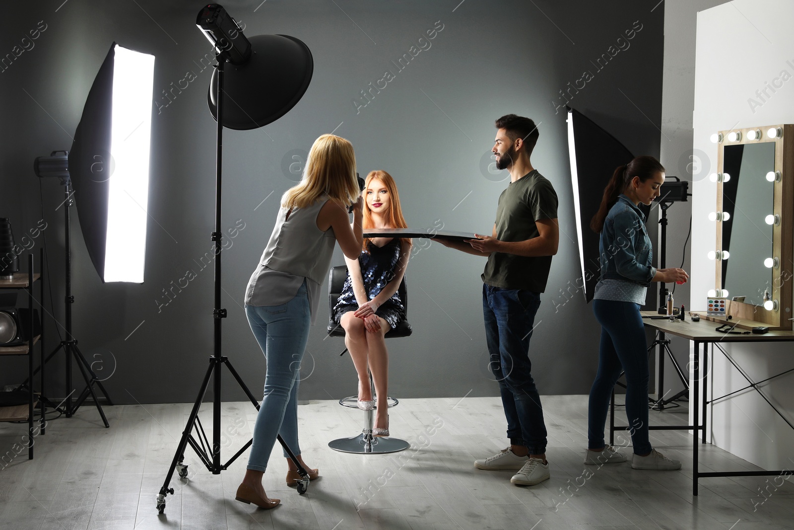 Photo of Photo studio with professional equipment and team of workers