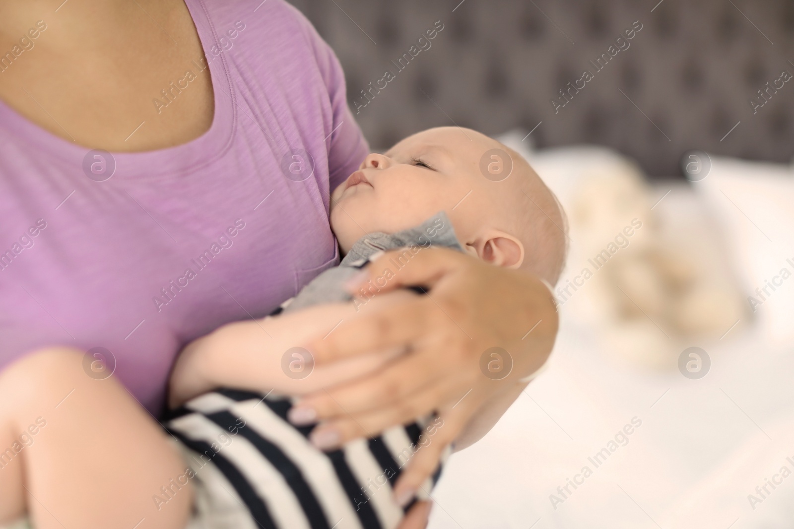 Photo of Mother with her sleeping baby at home, closeup view