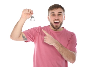 Happy young man with house key on white background