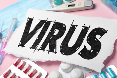 Photo of Word VIRUS and medicines on pink background