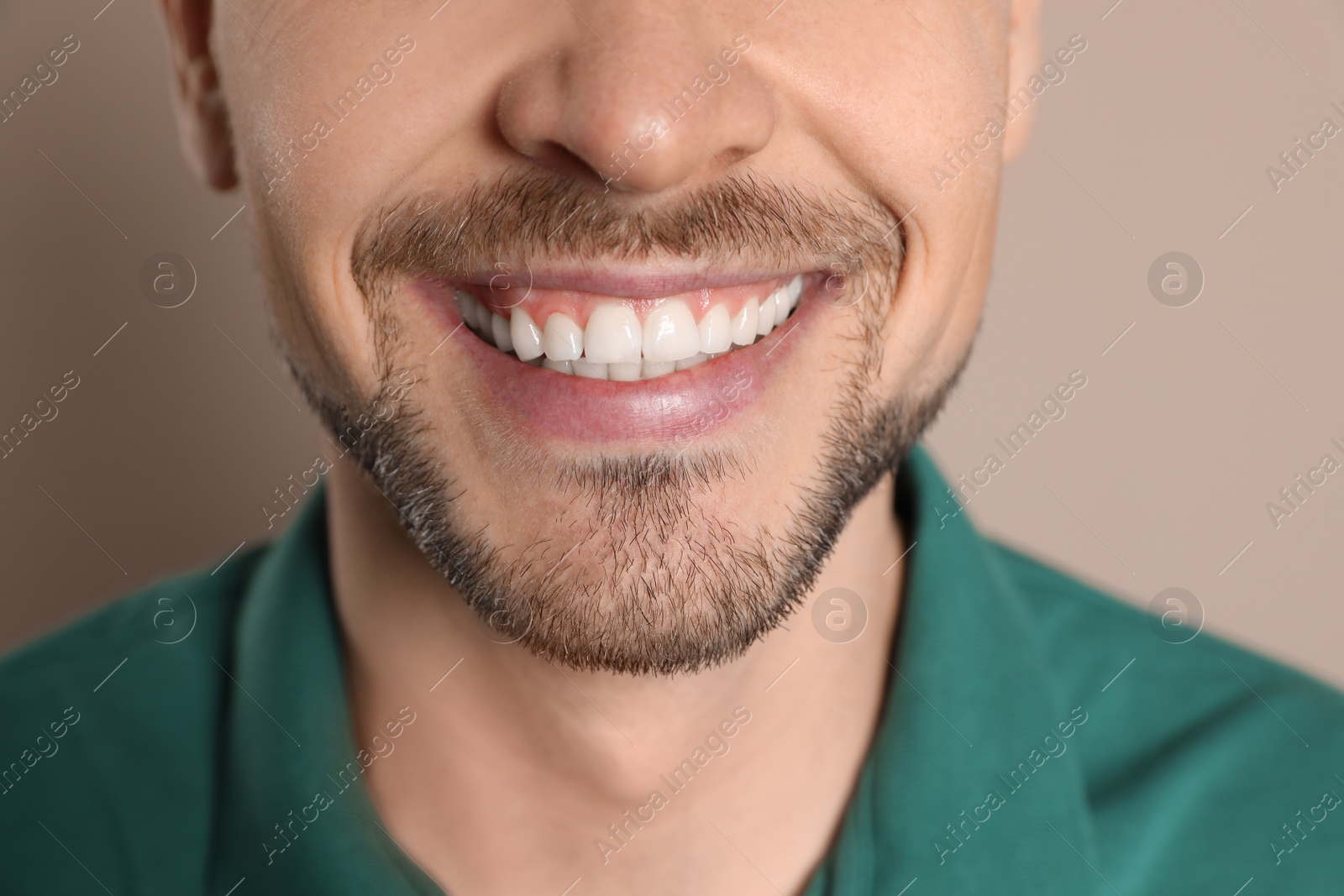 Photo of Smiling man with perfect teeth on color background, closeup