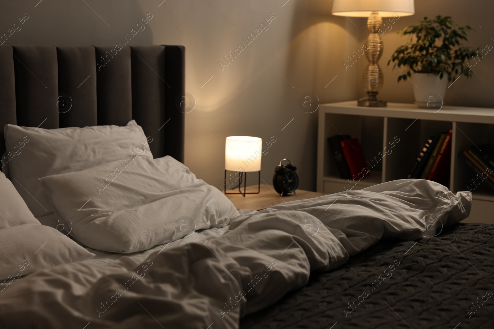 Photo of Soft bed, nightlight and cozy furniture indoors