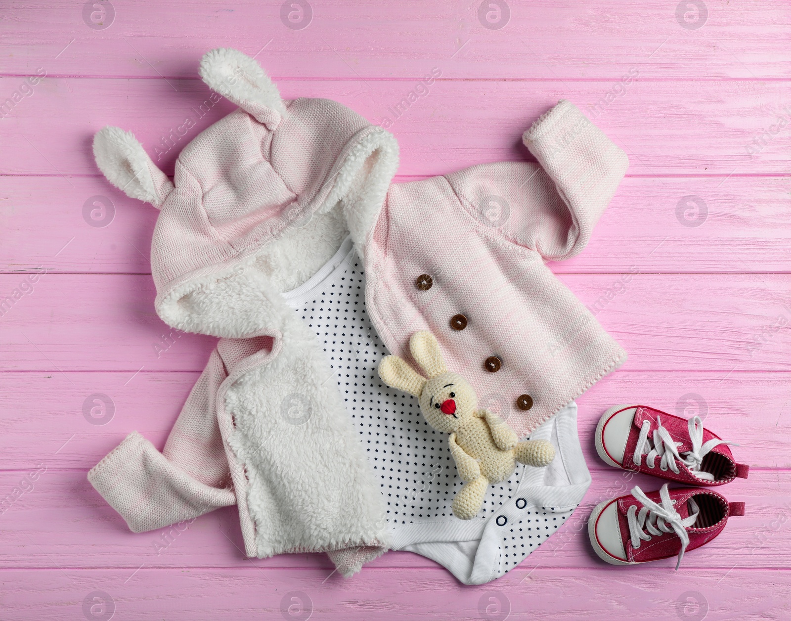 Photo of Flat lay composition with cute clothes on wooden background. Baby accessories