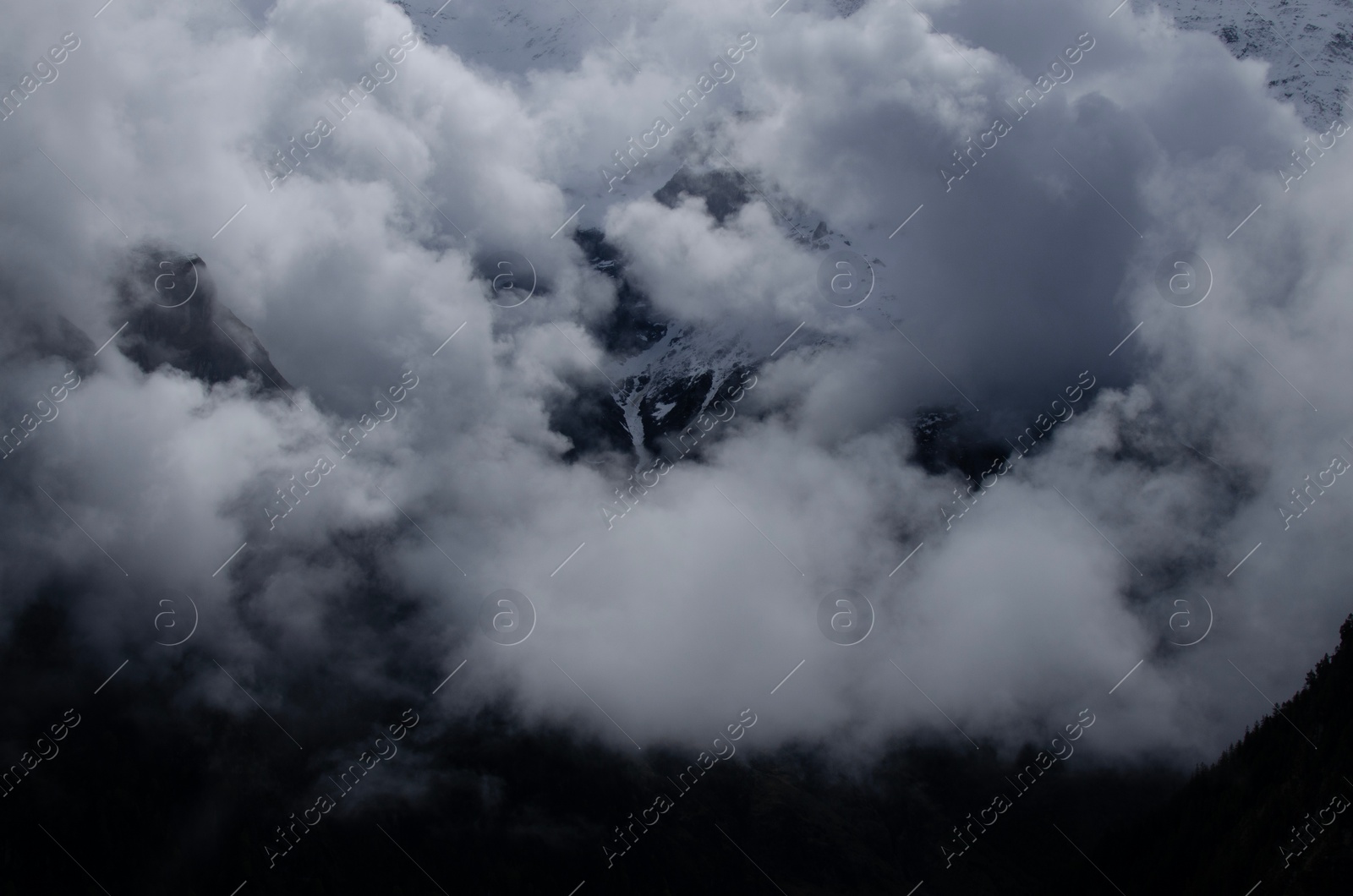 Photo of Picturesque view of high mountains covered with fog