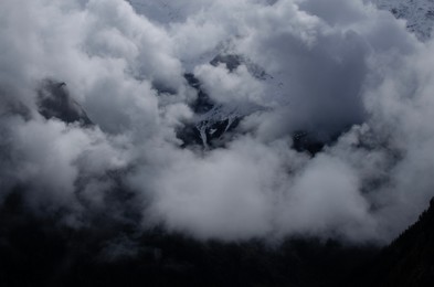 Picturesque view of high mountains covered with fog