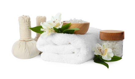 Photo of Spa composition. Towel, herbal massage bags, sea salt and beautiful flowers on white background