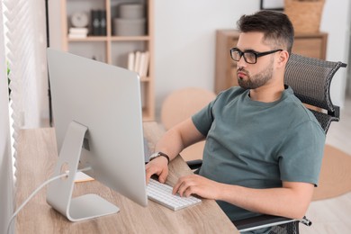 Programmer working with computer at desk in office