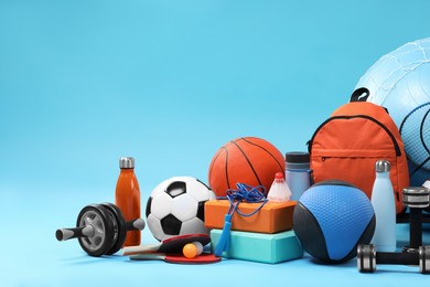 Photo of Many different sports equipment on light blue background, space for text