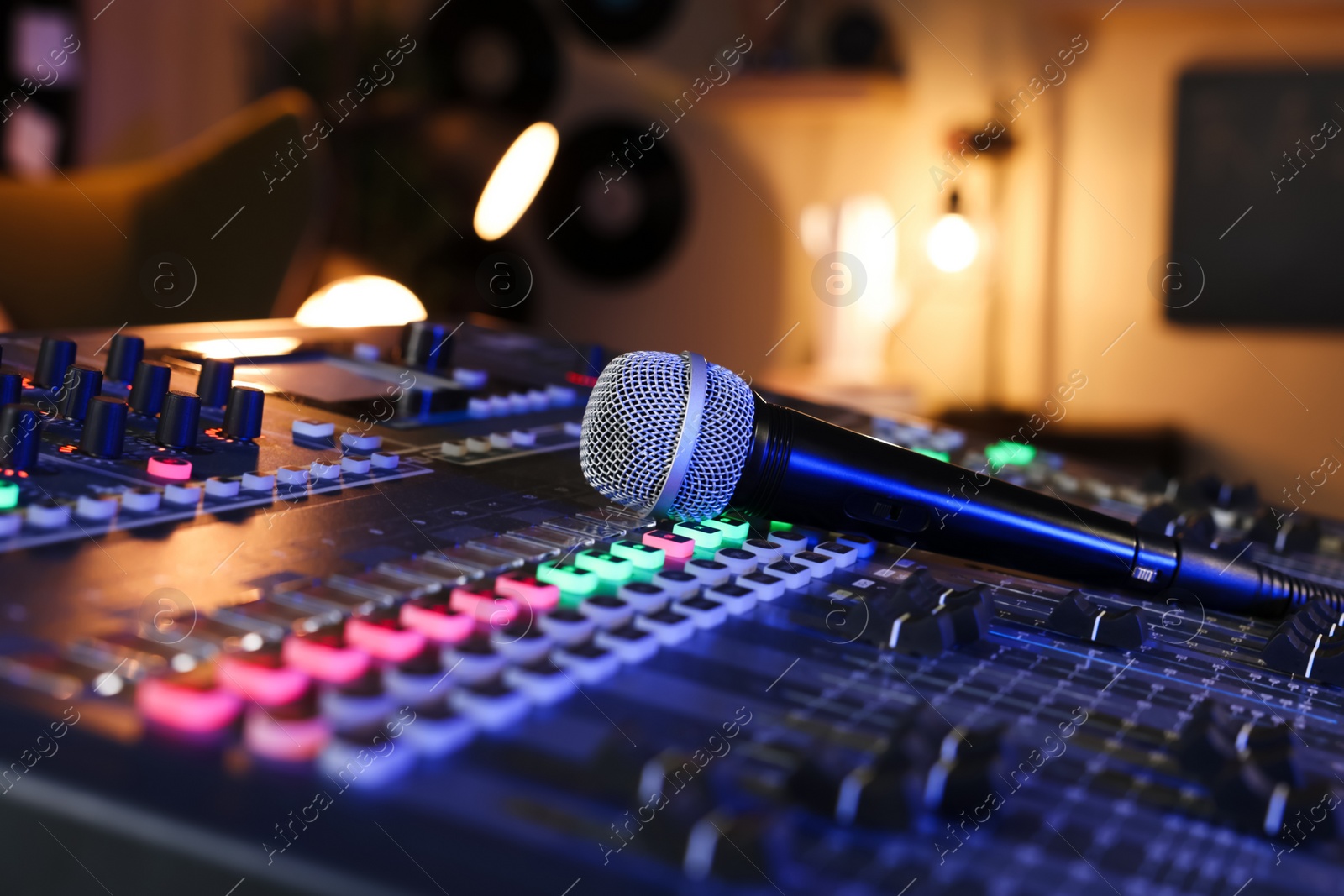 Photo of Microphone on professional mixing console in radio studio, closeup