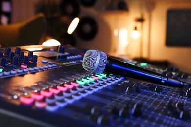Microphone on professional mixing console in radio studio, closeup