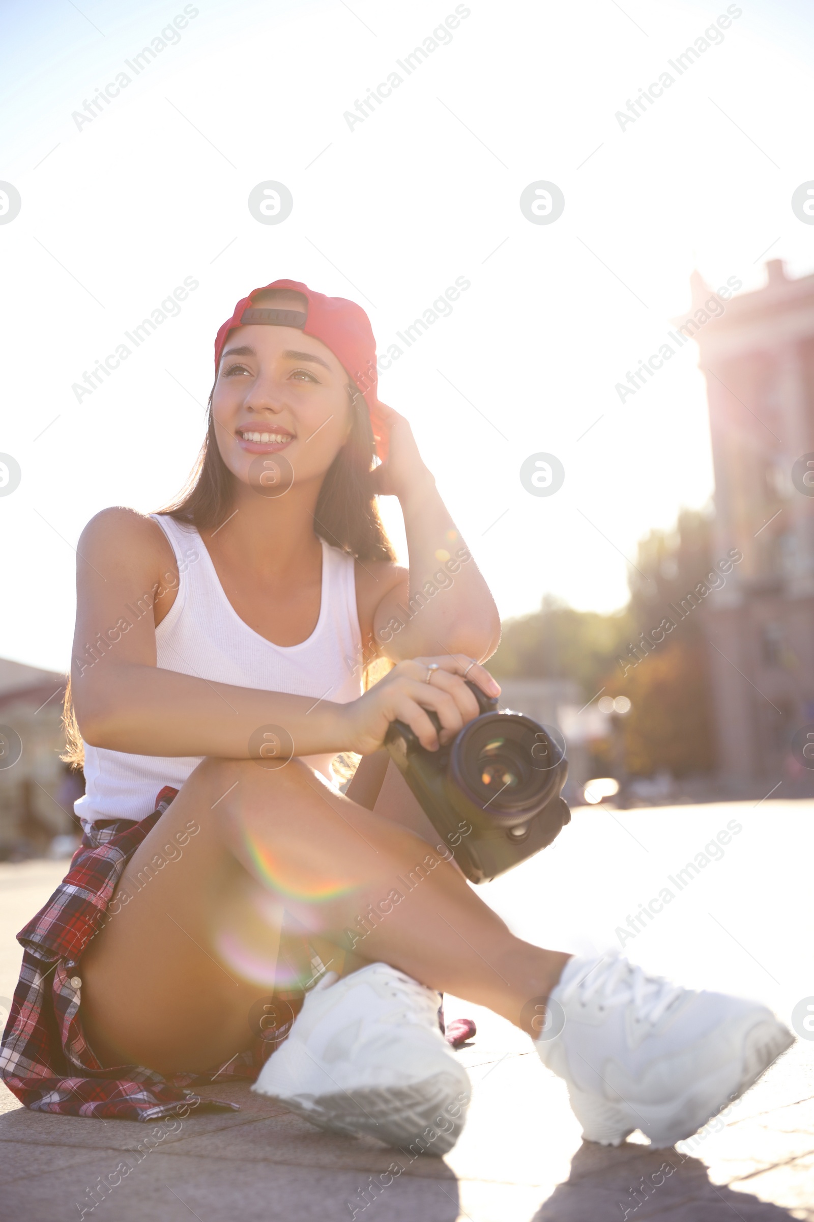 Photo of Young photographer with professional camera on city street