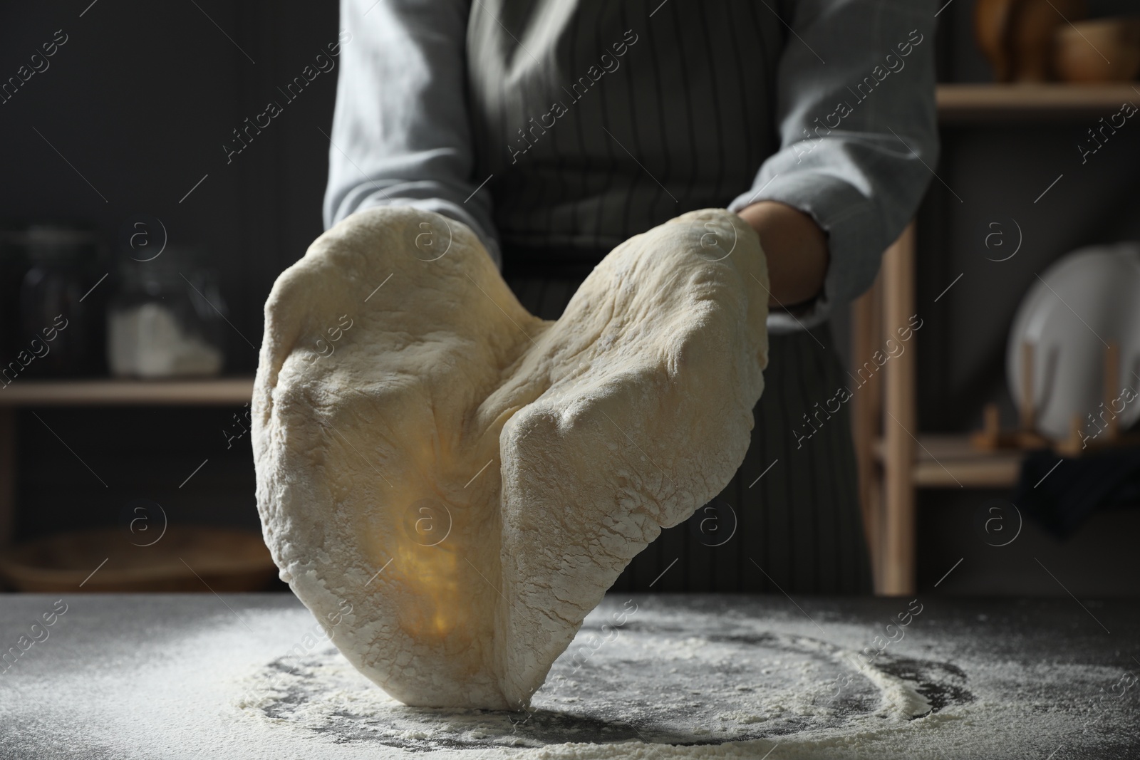 Photo of Woman making pizza dough at table, closeup