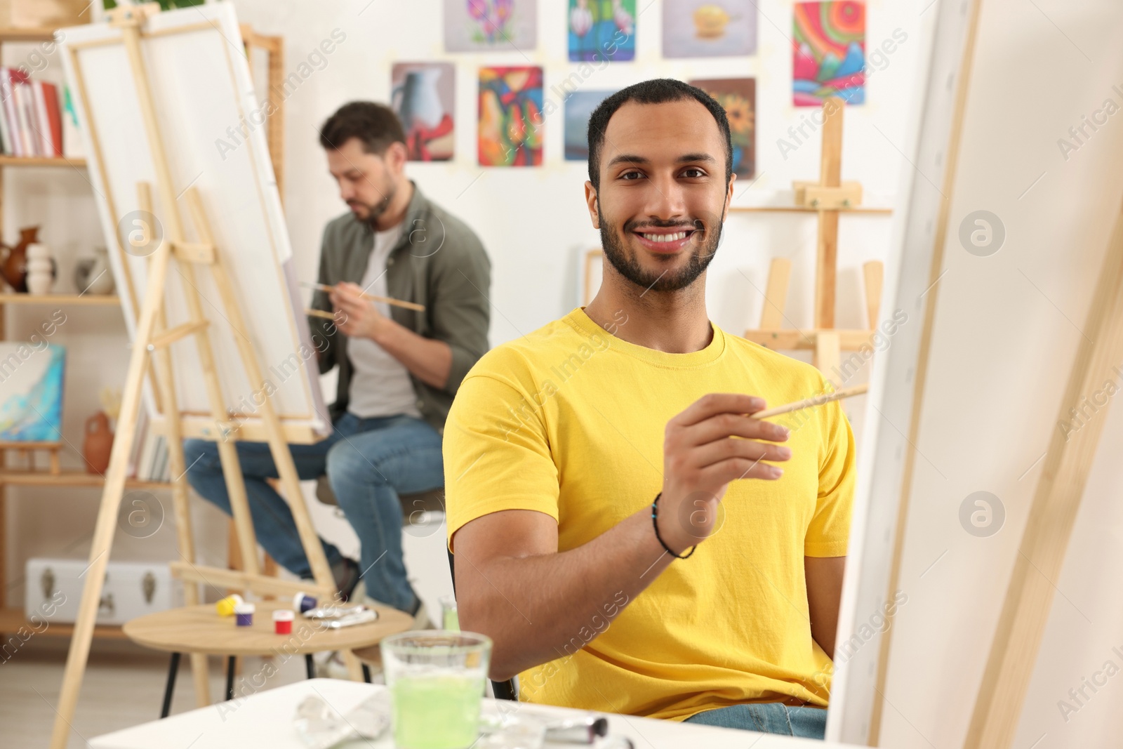 Photo of Group of students attending painting class in studio. Creative hobby