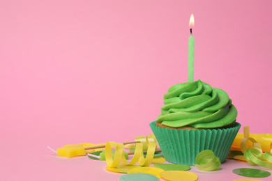 Photo of Delicious birthday cupcake with green cream and burning candle on pink background. Space for text