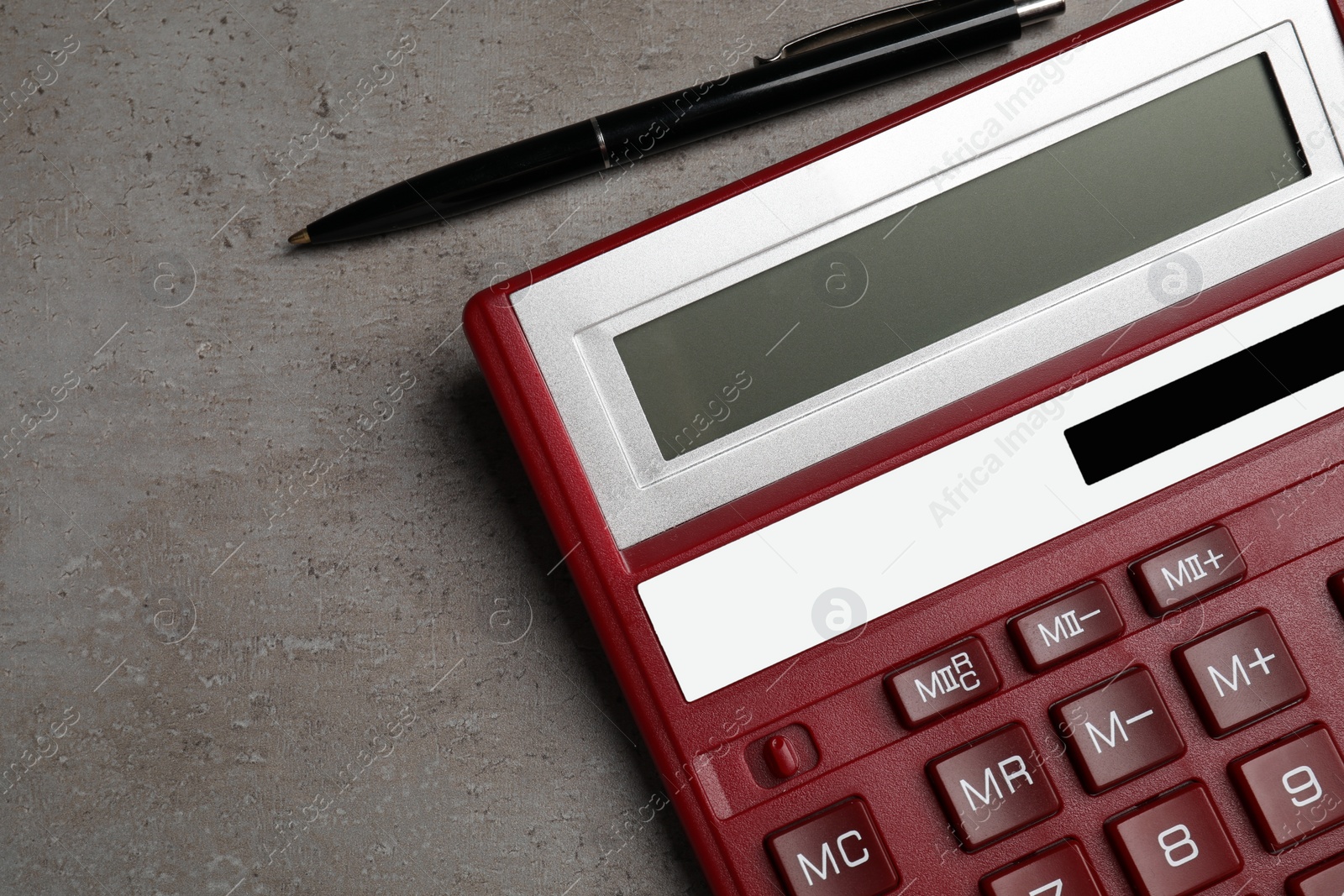 Photo of Calculator and pen on grey table, flat lay