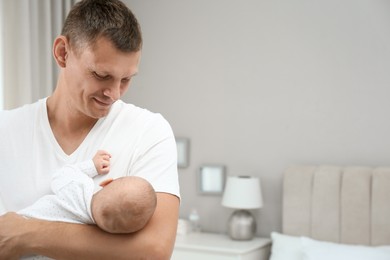 Photo of Happy father holding his cute baby at home, space for text