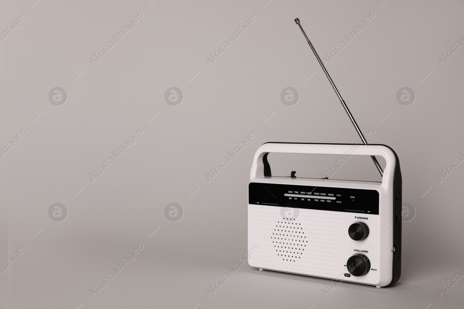 Photo of Portable retro radio receiver on grey background. Space for text