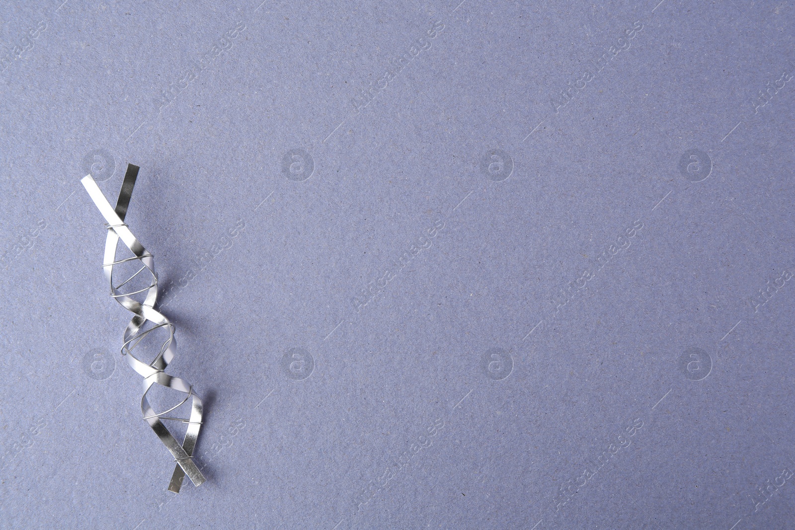 Photo of DNA molecular chain model made of metal on grey background, top view. Space for text