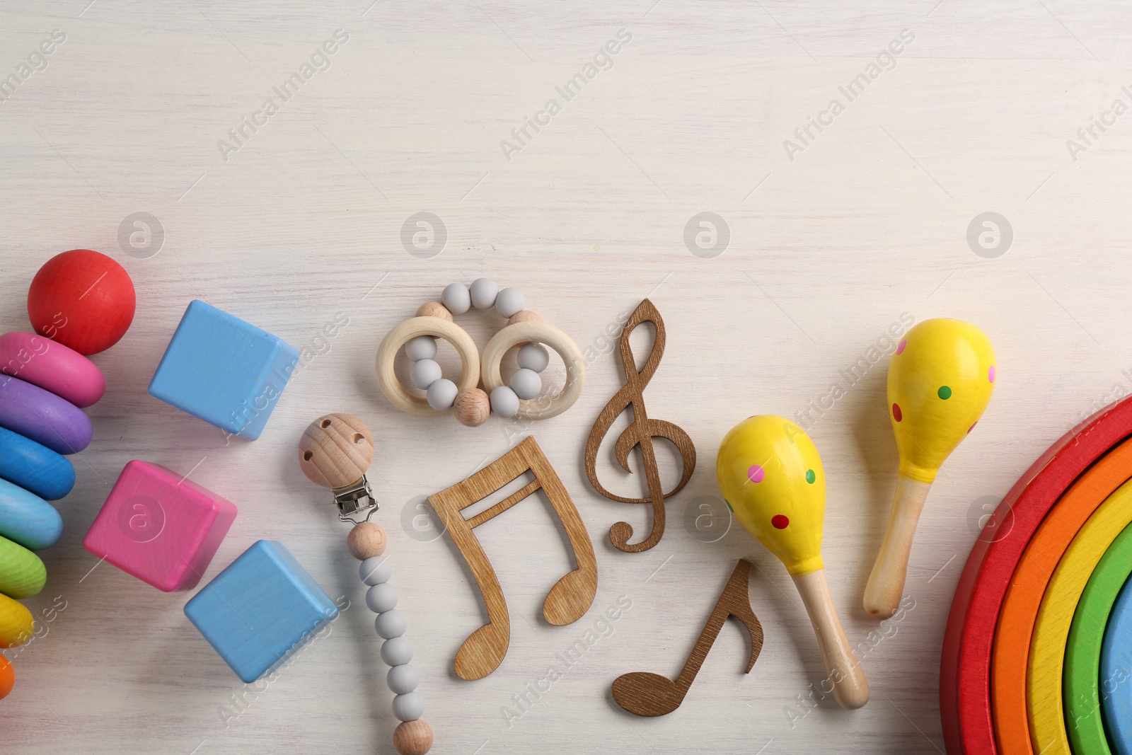 Photo of Baby song concept. Wooden notes, kids maracas and toys on table, flat lay. Space for text