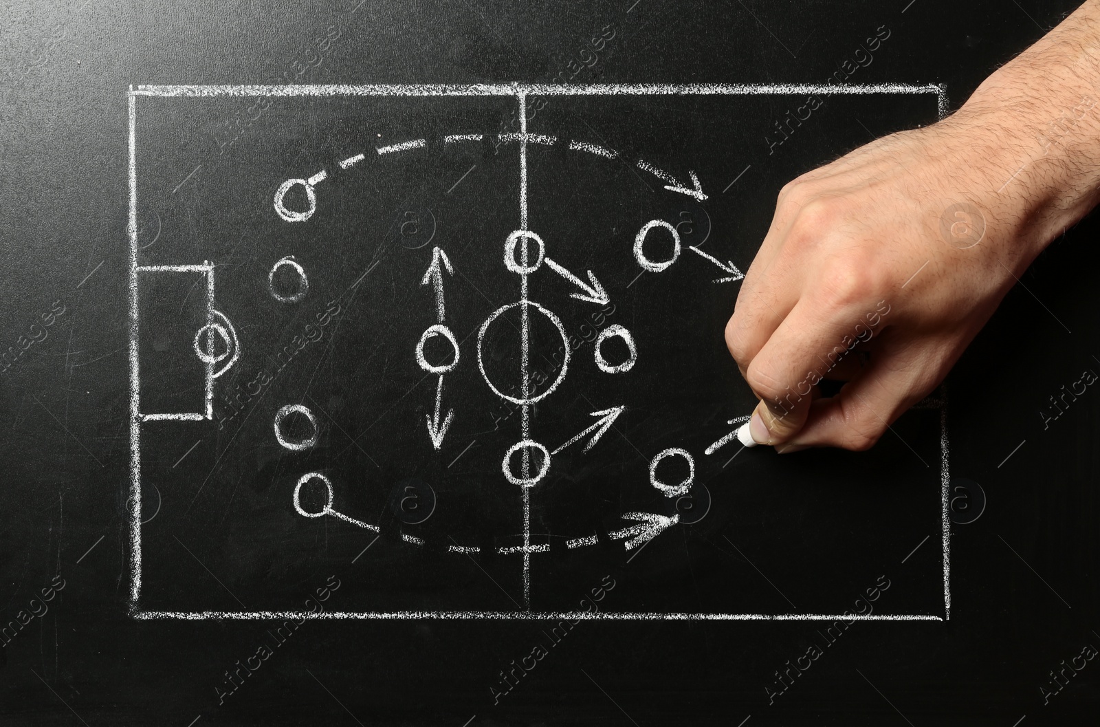 Photo of Man drawing football game scheme on chalkboard, top view