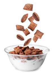 Sweet crispy corn pads falling into bowl with milk on white background 