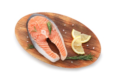 Wooden board with fresh salmon steak and lemon on white background, top view