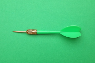 Photo of Plastic dart arrow on green background, top view