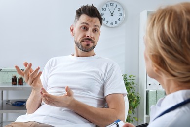 Photo of Doctor listening to patient's complaints during consultation in clinic