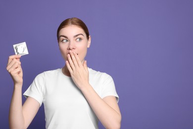 Photo of Woman holding condom on purple background, space for text. Safe sex