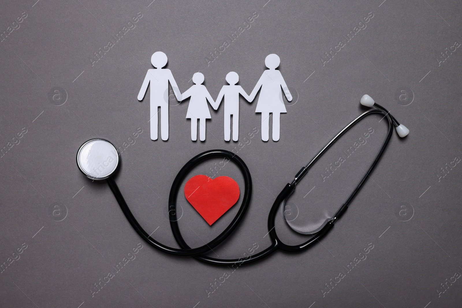 Photo of Paper family figures, red heart and stethoscope on grey background, flat lay. Insurance concept