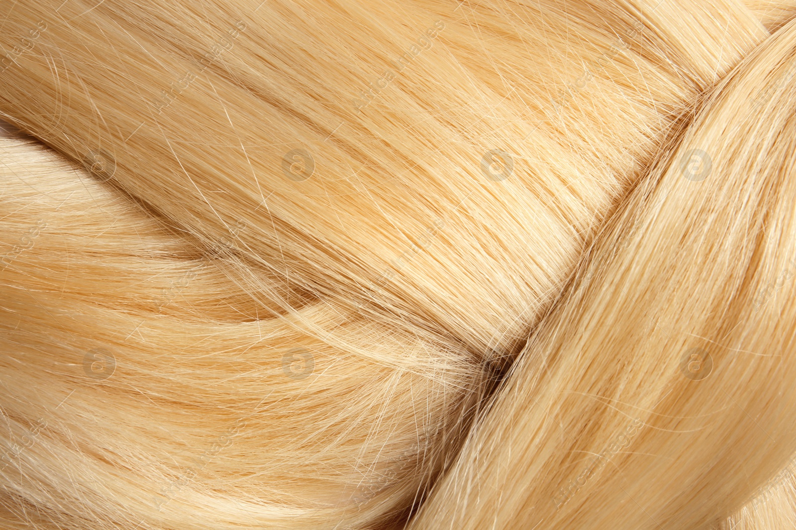 Photo of Healthy braided blond hair as background, closeup